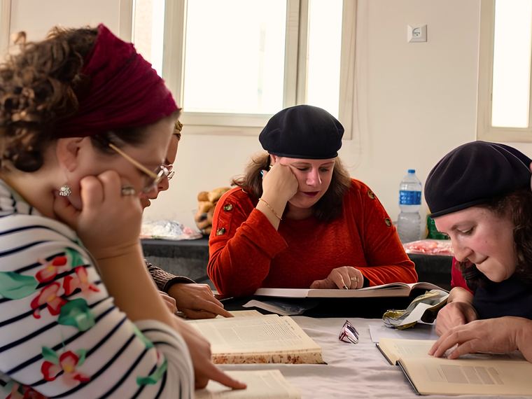 Three women studying Jewish texts together around a table