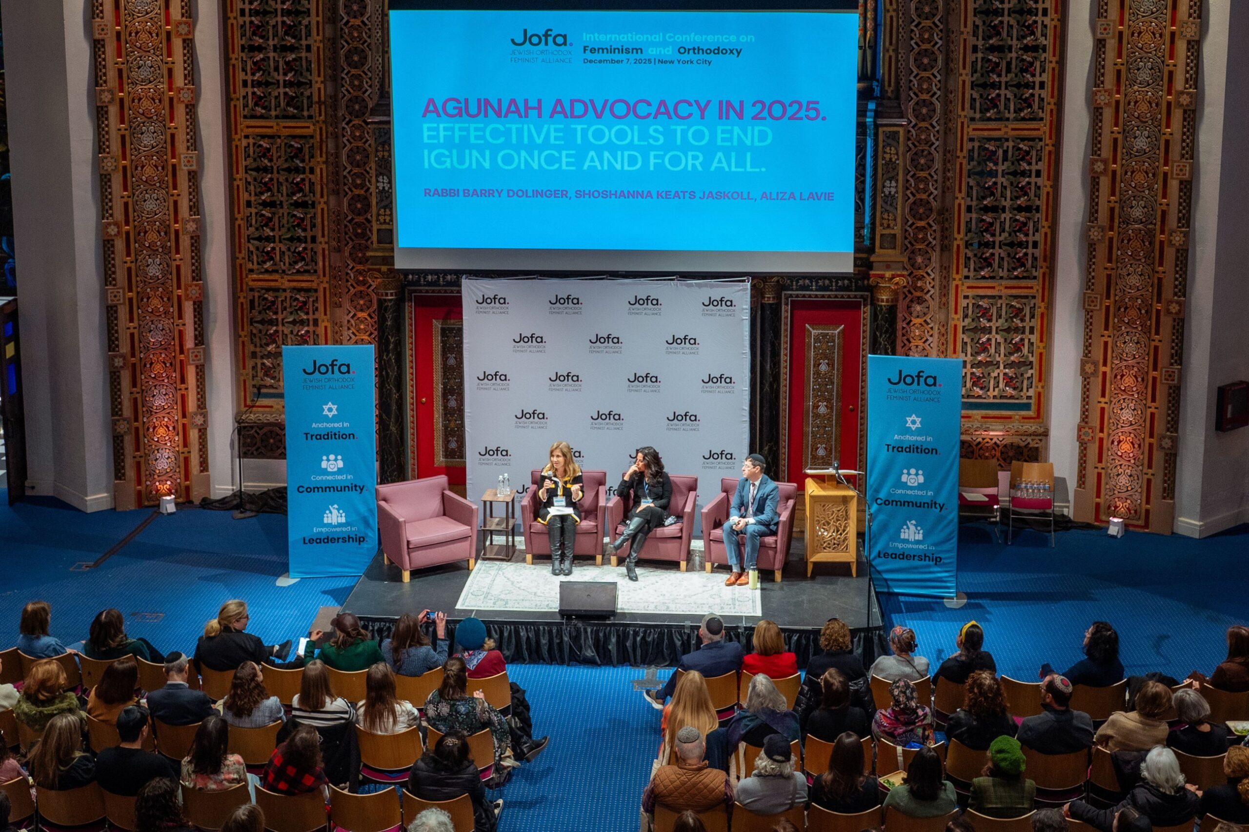 Panel discussion on stage at a Jofa conference before a seated audience